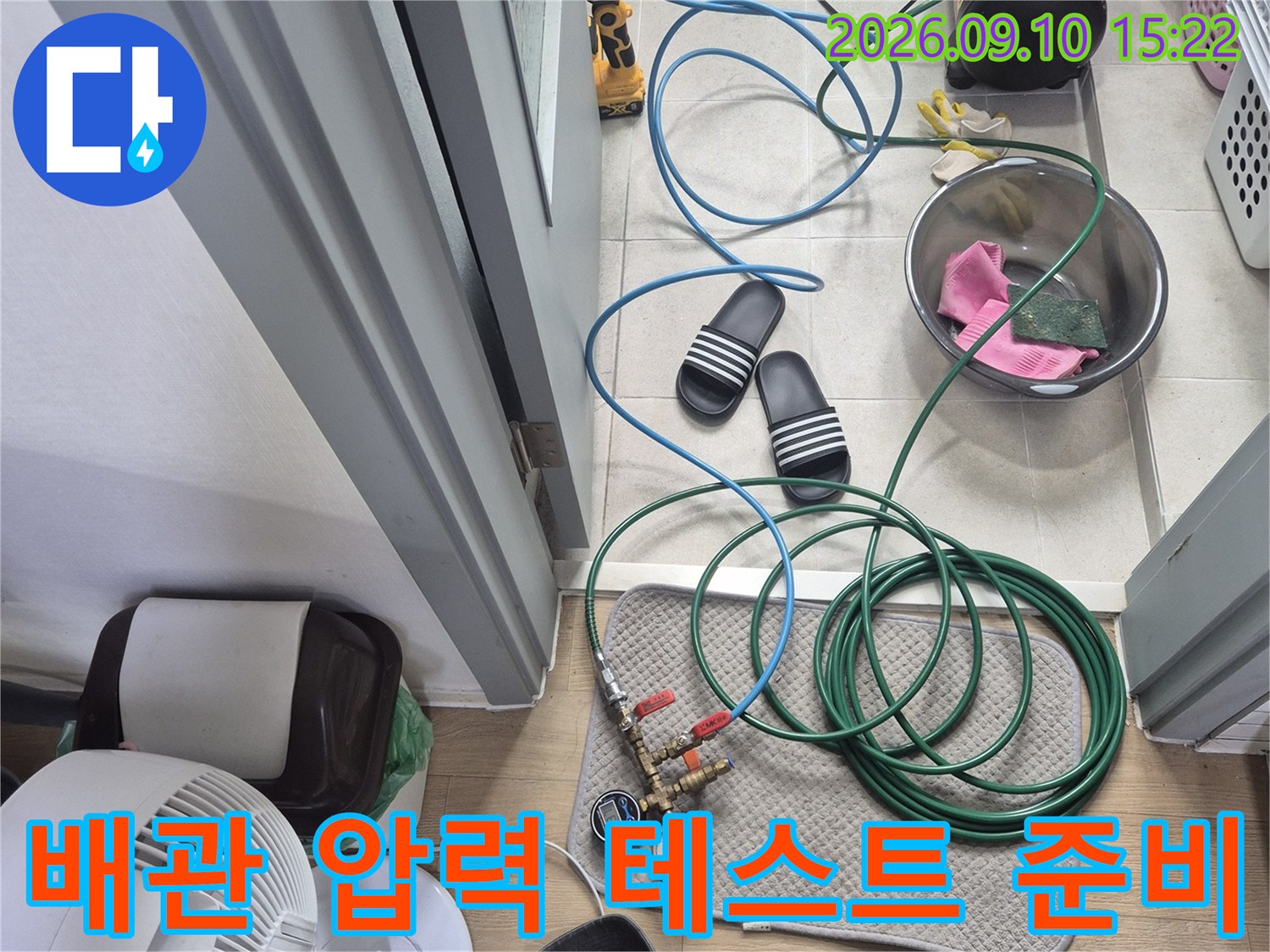 수도 배관의 누수 여부를 판단하기 위해 설치된 공압 테스트 장비와 호스입니다.