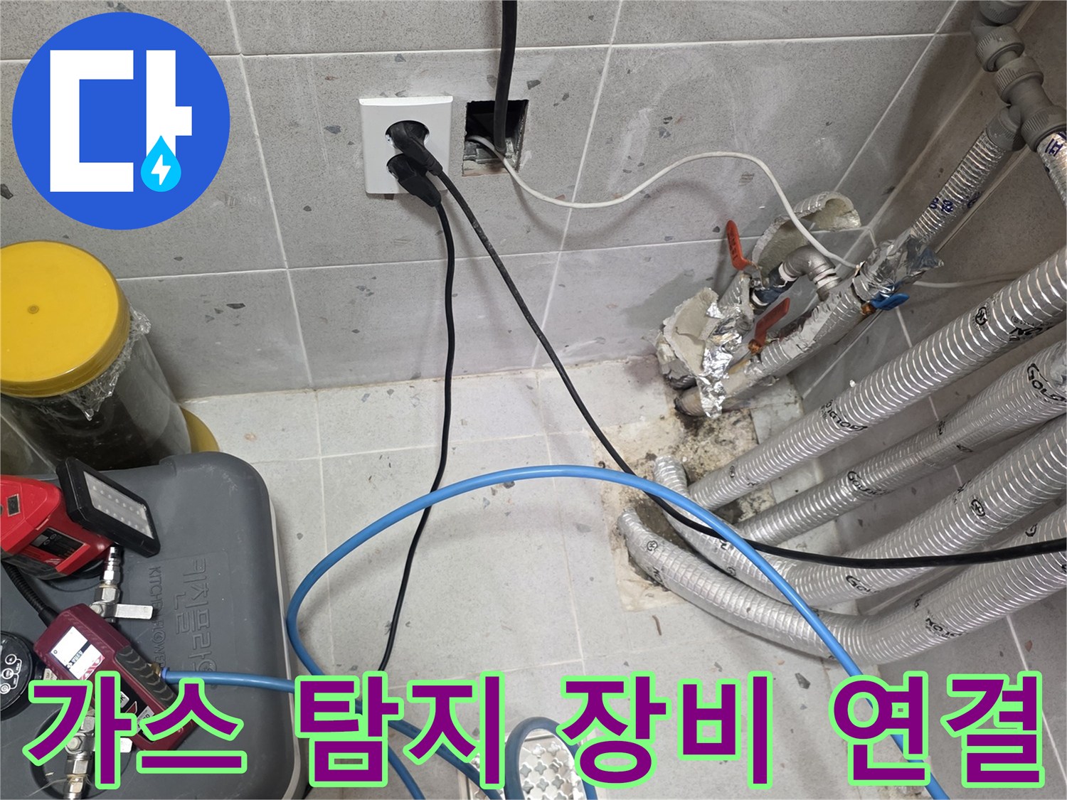 측정 장비와 파란색 호스가 복잡한 배관 뭉치에 연결된 현장 사진입니다.