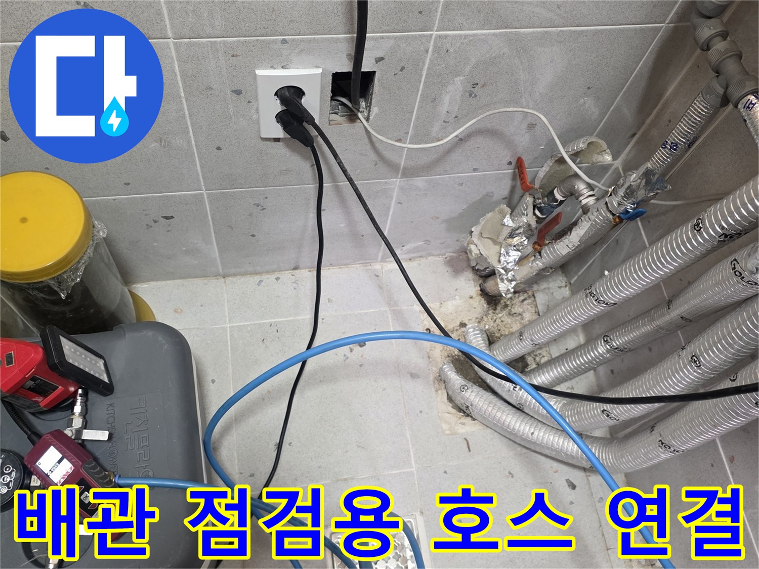 타일벽 배관 뭉치와-압력 테스트를 위해 연결된 파란색 호스들