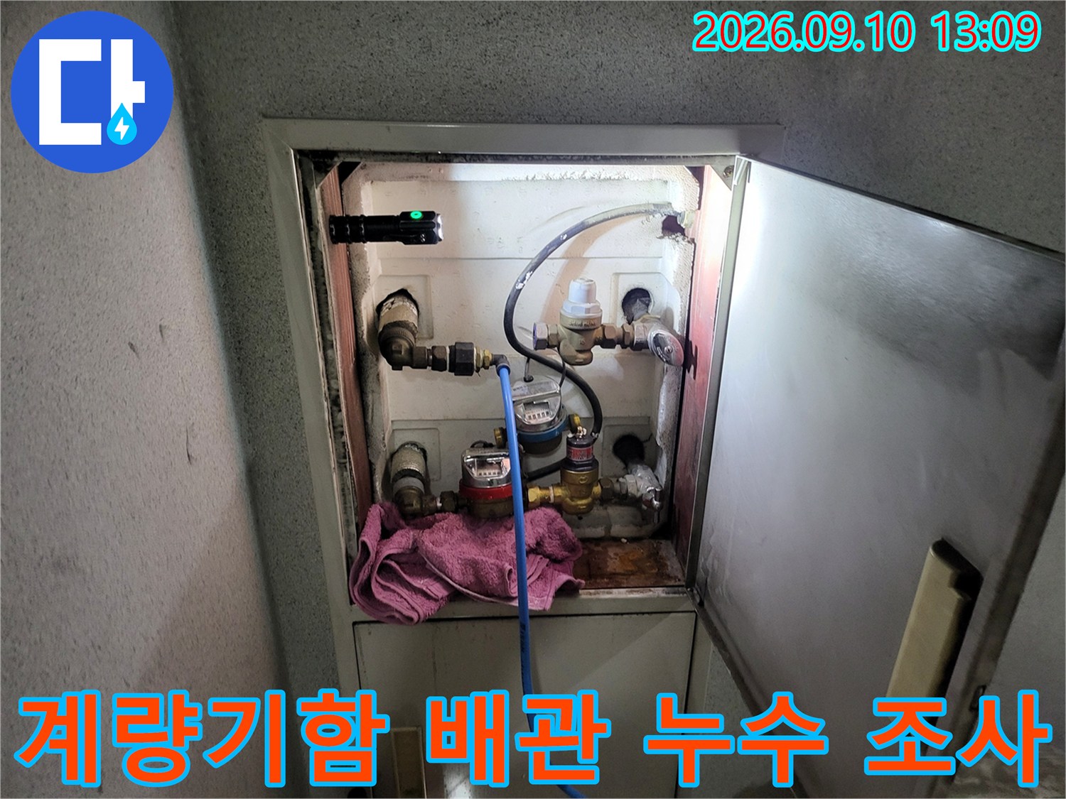 수도 계량기가 설치된 양수기함 내부의 배관 연결 상태를 점검하는 모습입니다.