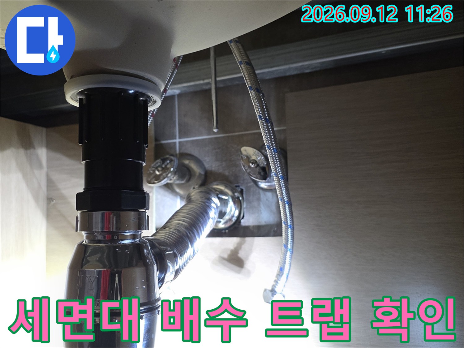 세면대 하부 배수 트랩과 급수 호스 연결 부위 사진