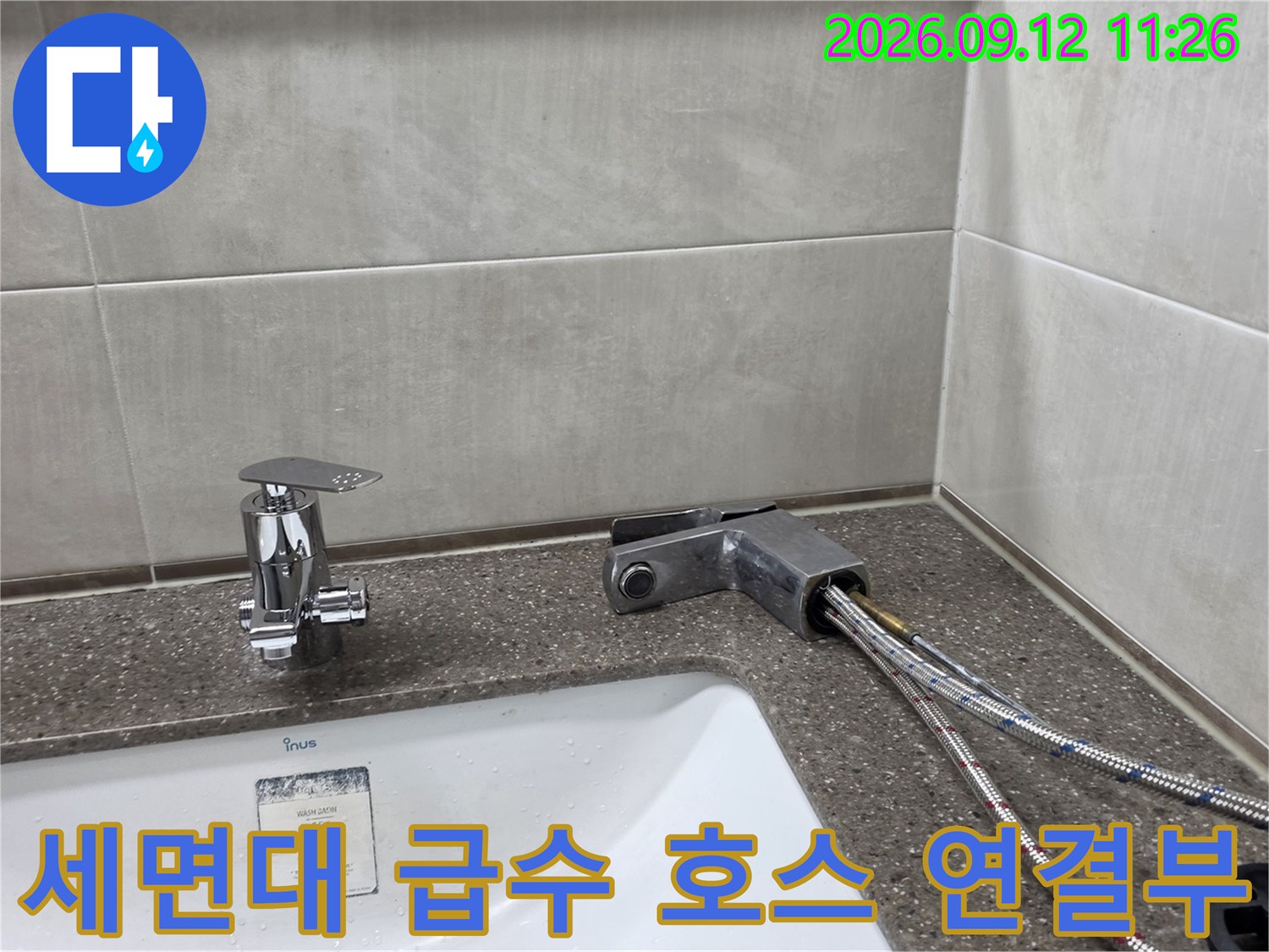 은색 수전과 벽면에 설치된 스테인리스 급수 호스 상세