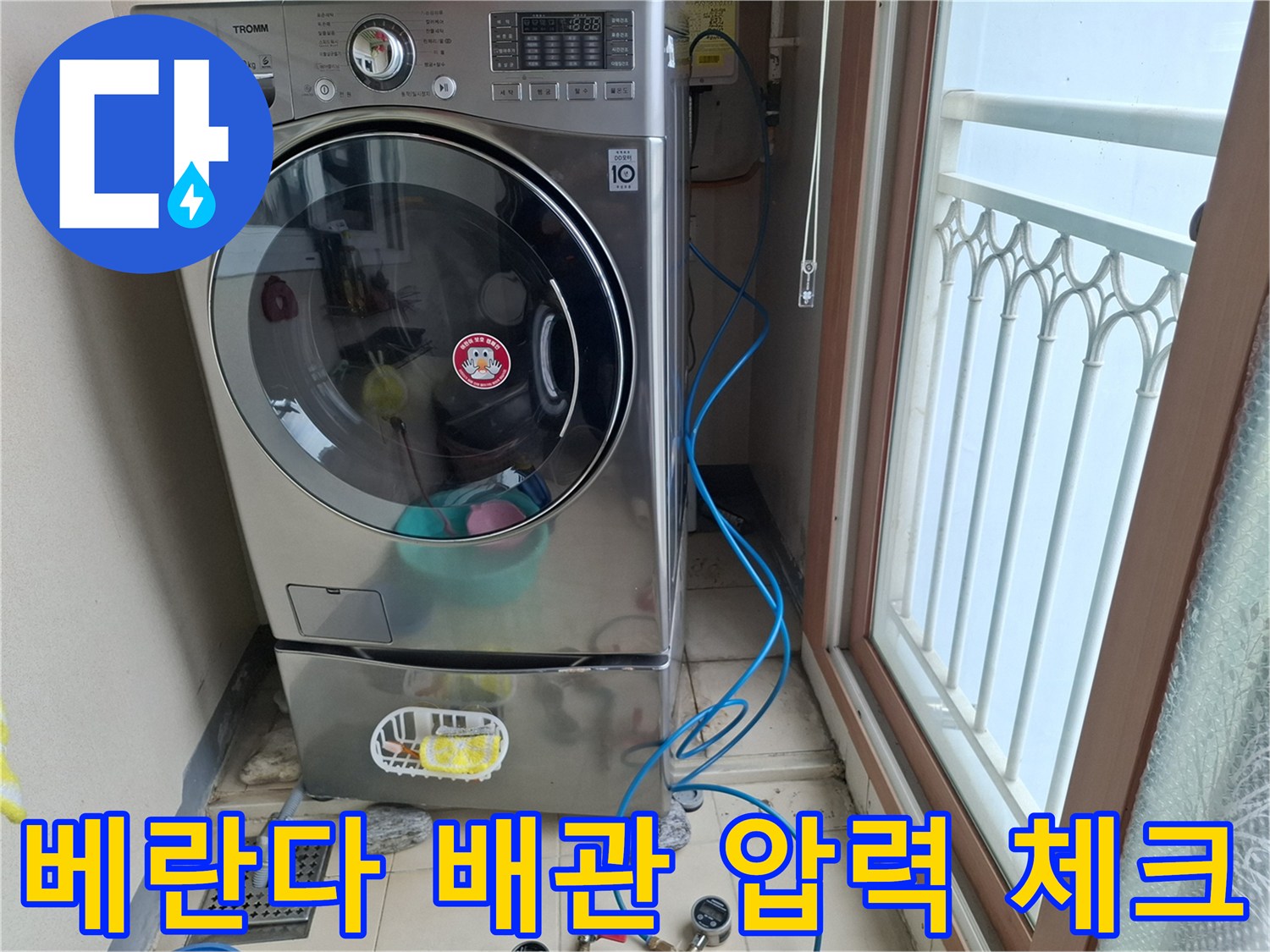 세탁기 주변 바닥의 배관 및 공압 테스트용 호스 연결 모습
