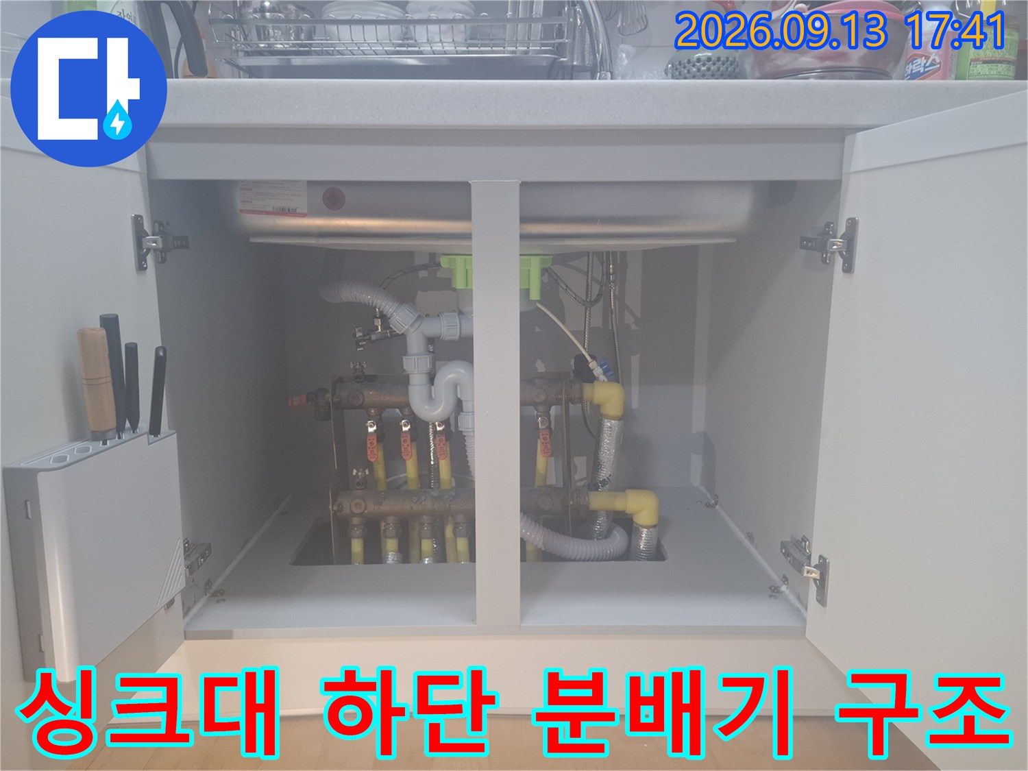 싱크대 밑에 위치한 보일러 분배기와 연결된 여러 갈래의 배관들