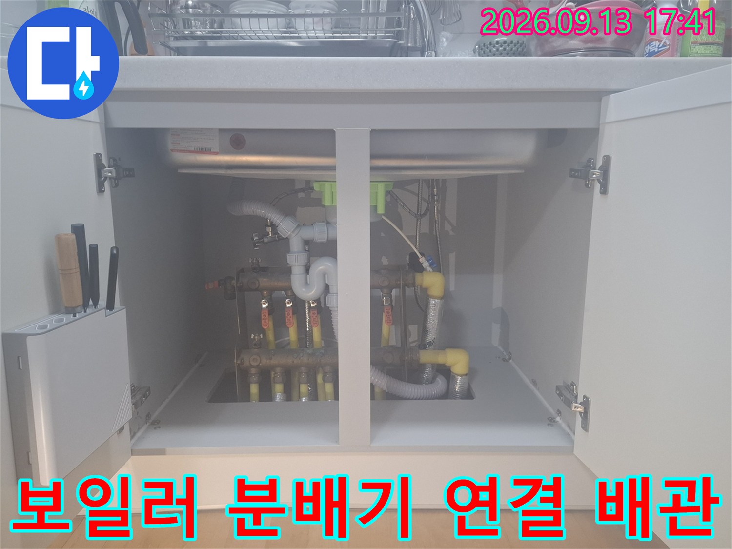 싱크대 하단 보일러 분배기의 노란색 배관과 금속 부속 연결 상태