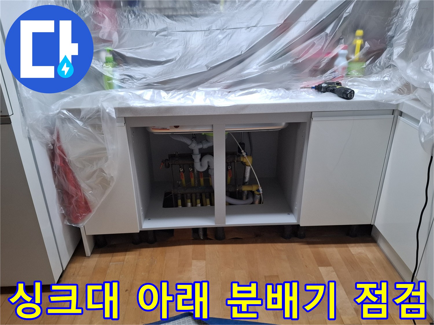 싱크대 하부장에 노출된 난방 분배기와 연결 부속들