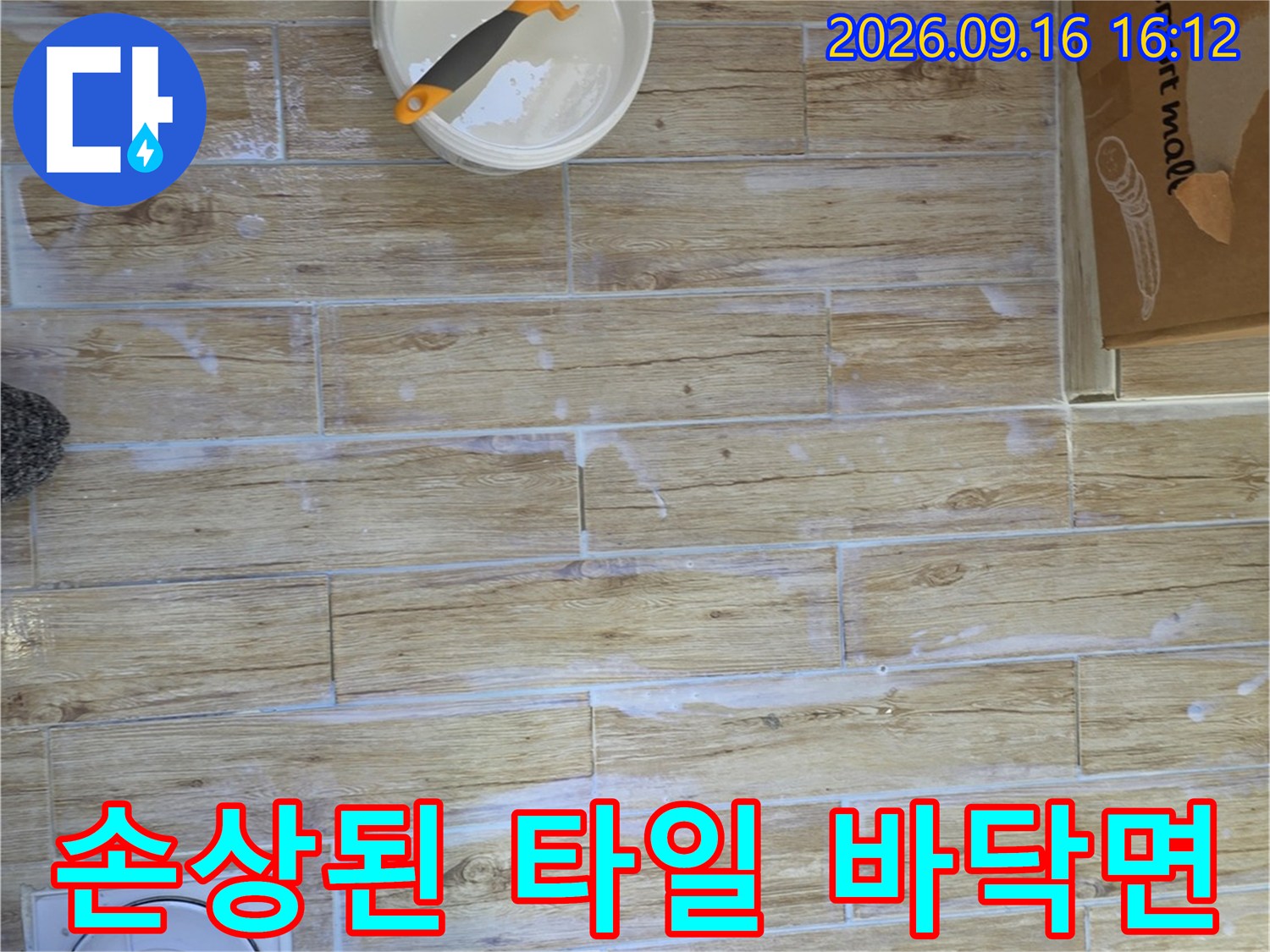 누수로 인해 변색과 오염이 발생한 타일 바닥의 모습입니다.