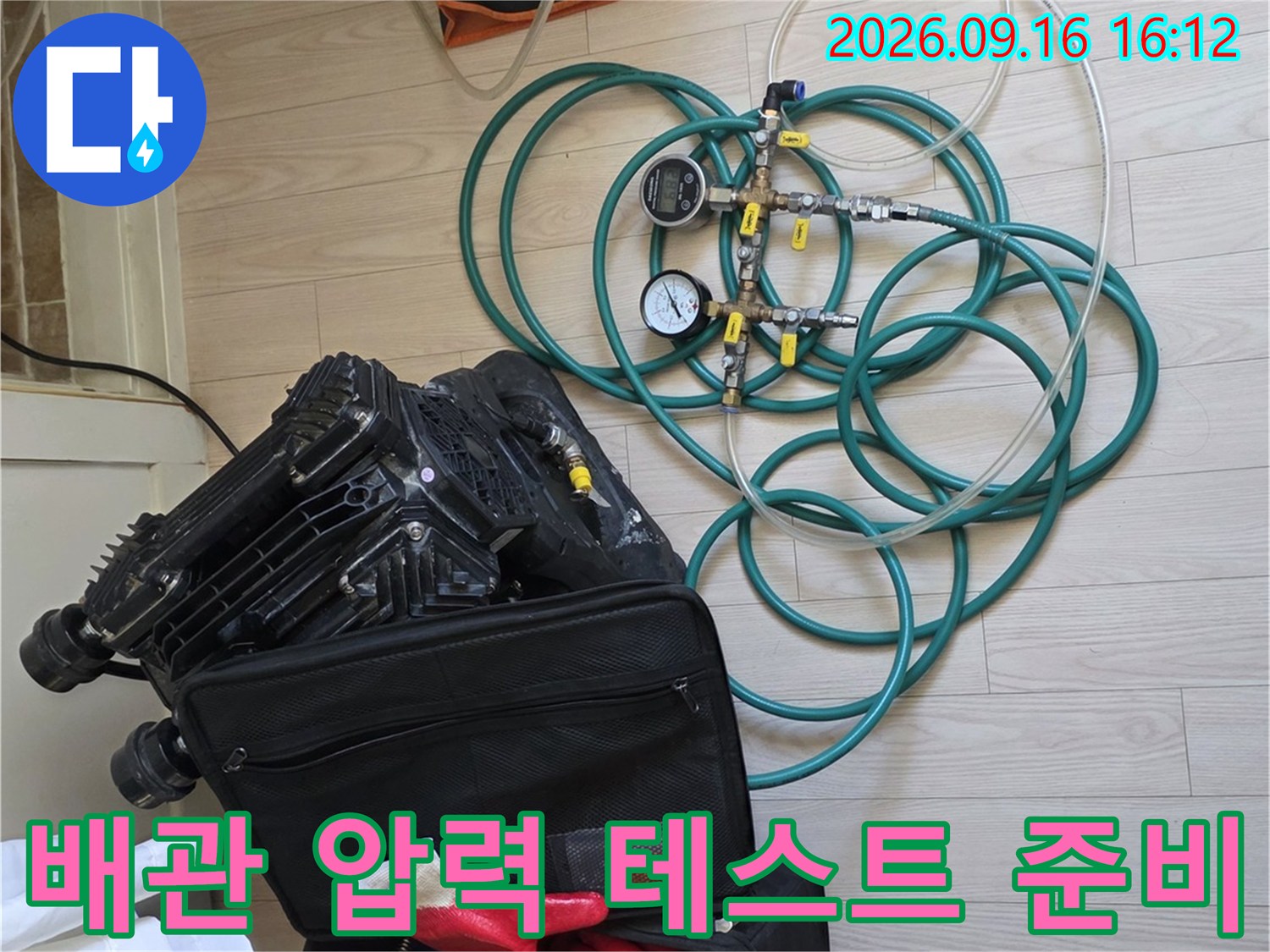 바닥에 놓인 누수 탐지용 게이지와 작업용 장갑 및 호스들