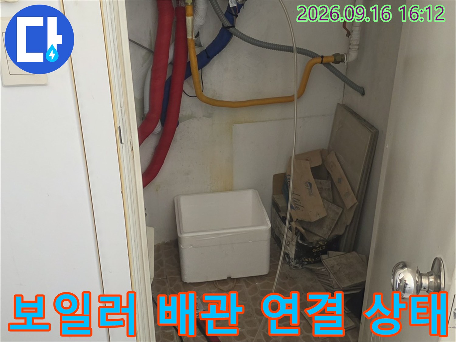 벽면에 고정된 흰색 배관과 노란색 호스의 접합 부위 근접 촬영