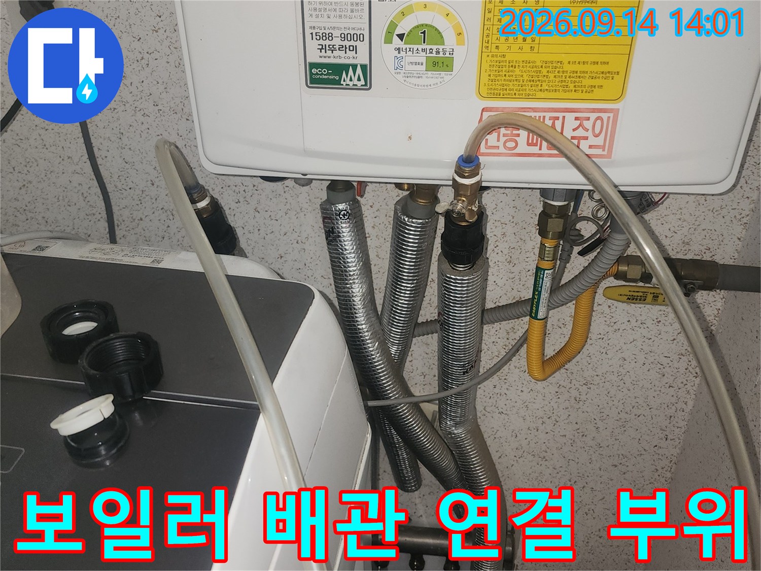 보일러 하단의 금속 배관과 플라스틱 호스 연결 상세 사진