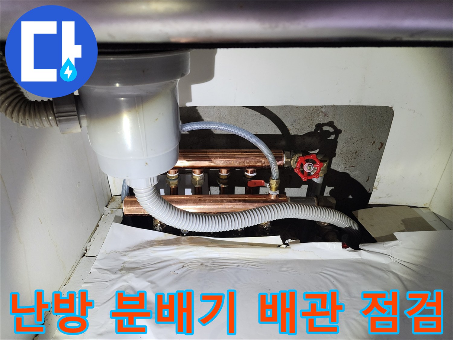 지하 공간의 난방 배관 연결 부위와 밸브 장치를 상세히 촬영한 사진