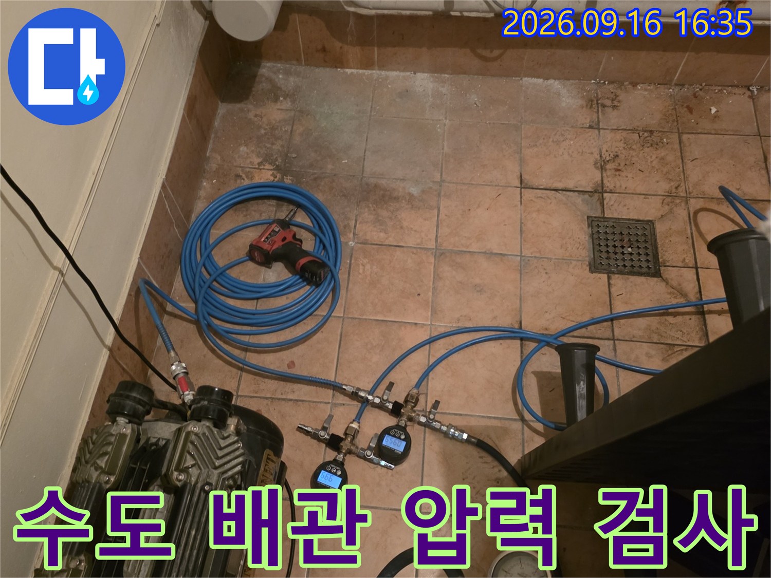 타일 바닥에 설치된 - 배관 압력 측정용 게이지와 호스입니다.