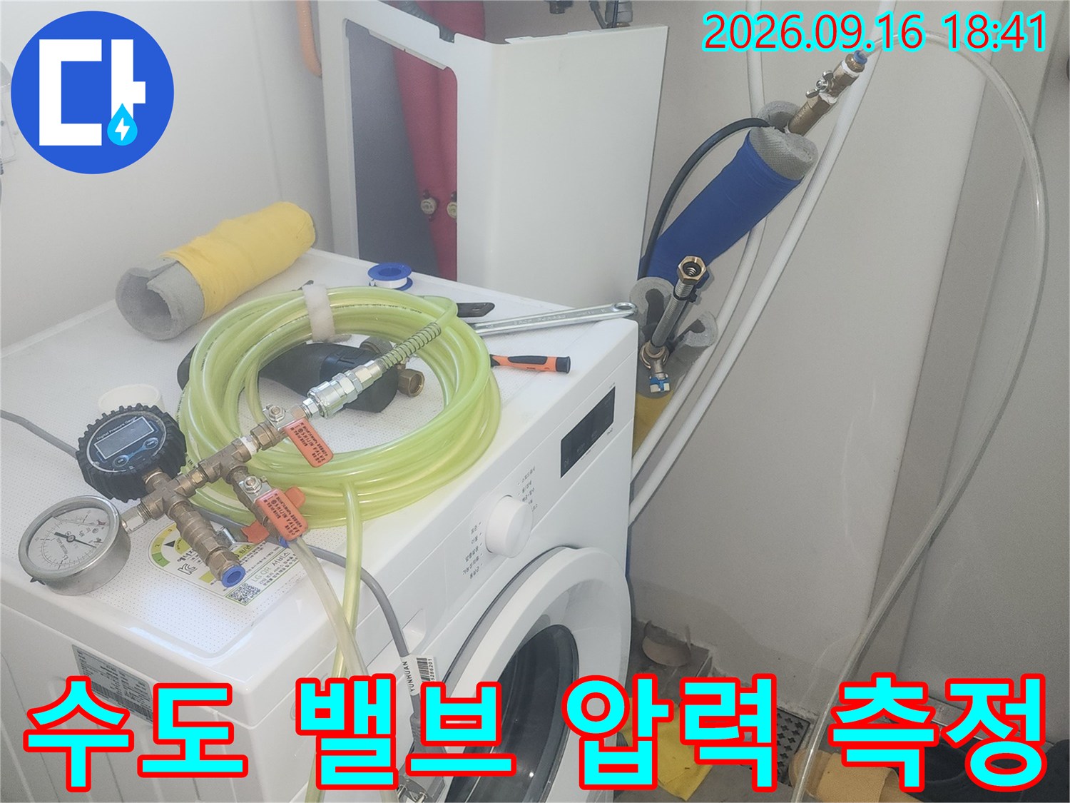 세탁실 수전 부위의 배관 연결 상태와 압력계 설치 모습입니다.