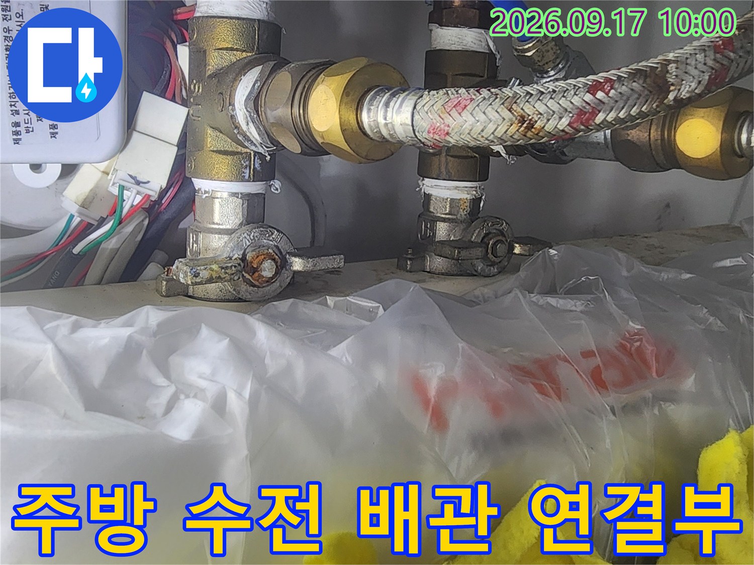 금속 부품과 호스가 연결된 싱크대 하단 급수 구조