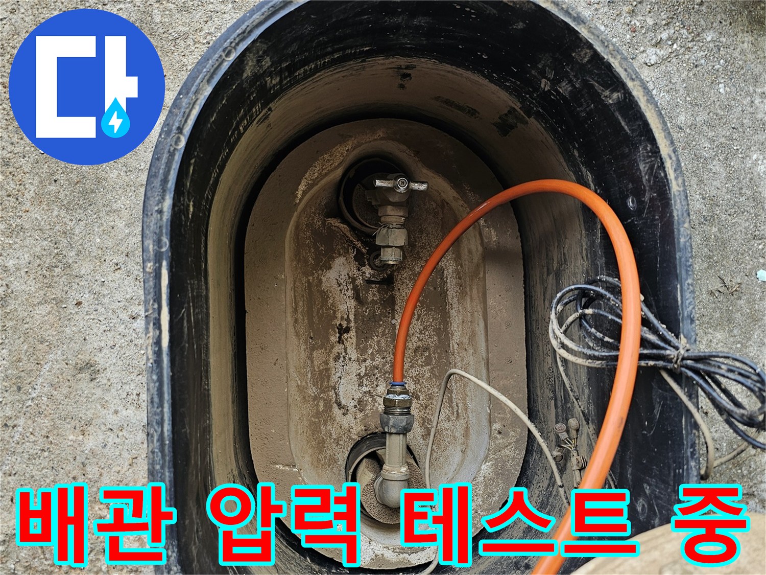 주황색 호스가 연결된 배관 부속의 근접 촬영